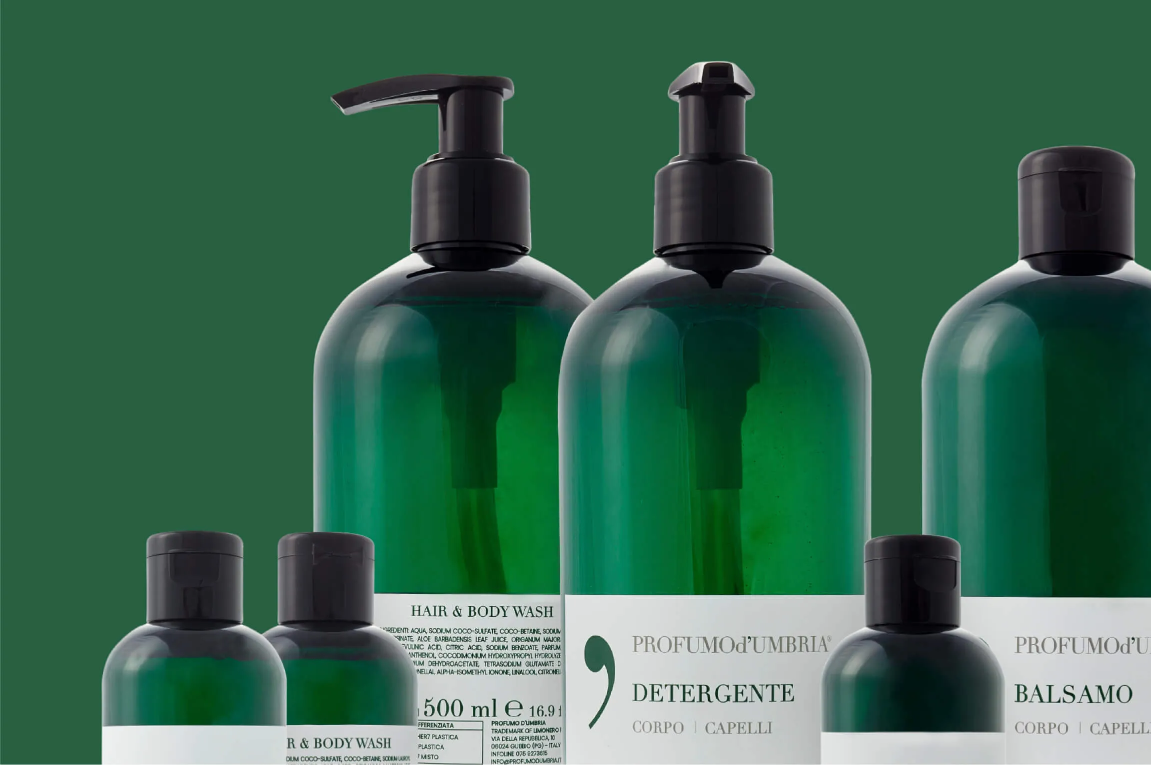 Green bottles of Profumo d’Umbria personal care products including hair and body wash with pump dispensers and balsamo with flip caps arranged against a green background.