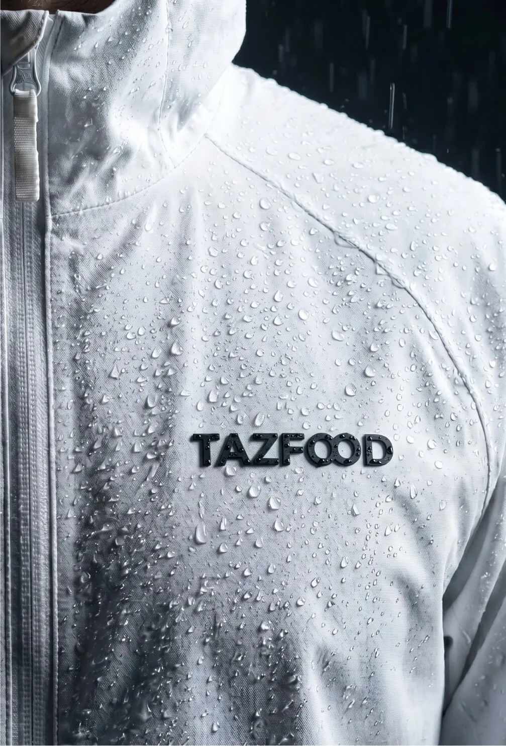 Close-up of a person wearing a white waterproof jacket with water droplets on it and the word 'TAZFOOD' printed on the chest, against a dark background with visible raindrops.