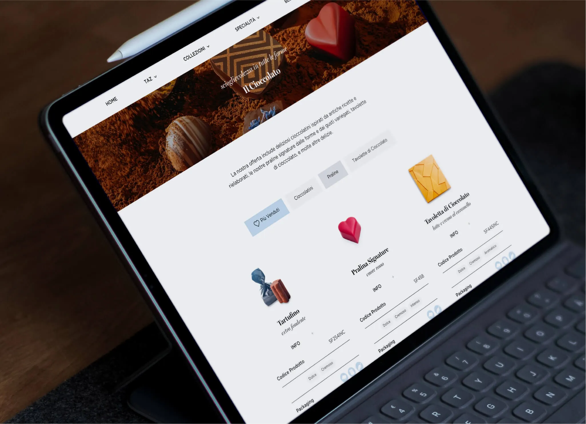 Tablet screen displaying an Italian chocolate product webpage with categories like 'Più Venduti', 'Cioccolatini', 'Praline', and images of chocolates including Tartufo, Pralina Signature shaped like a heart, and Tavoletta di Cioccolato, each with product info, codes, and packaging details.