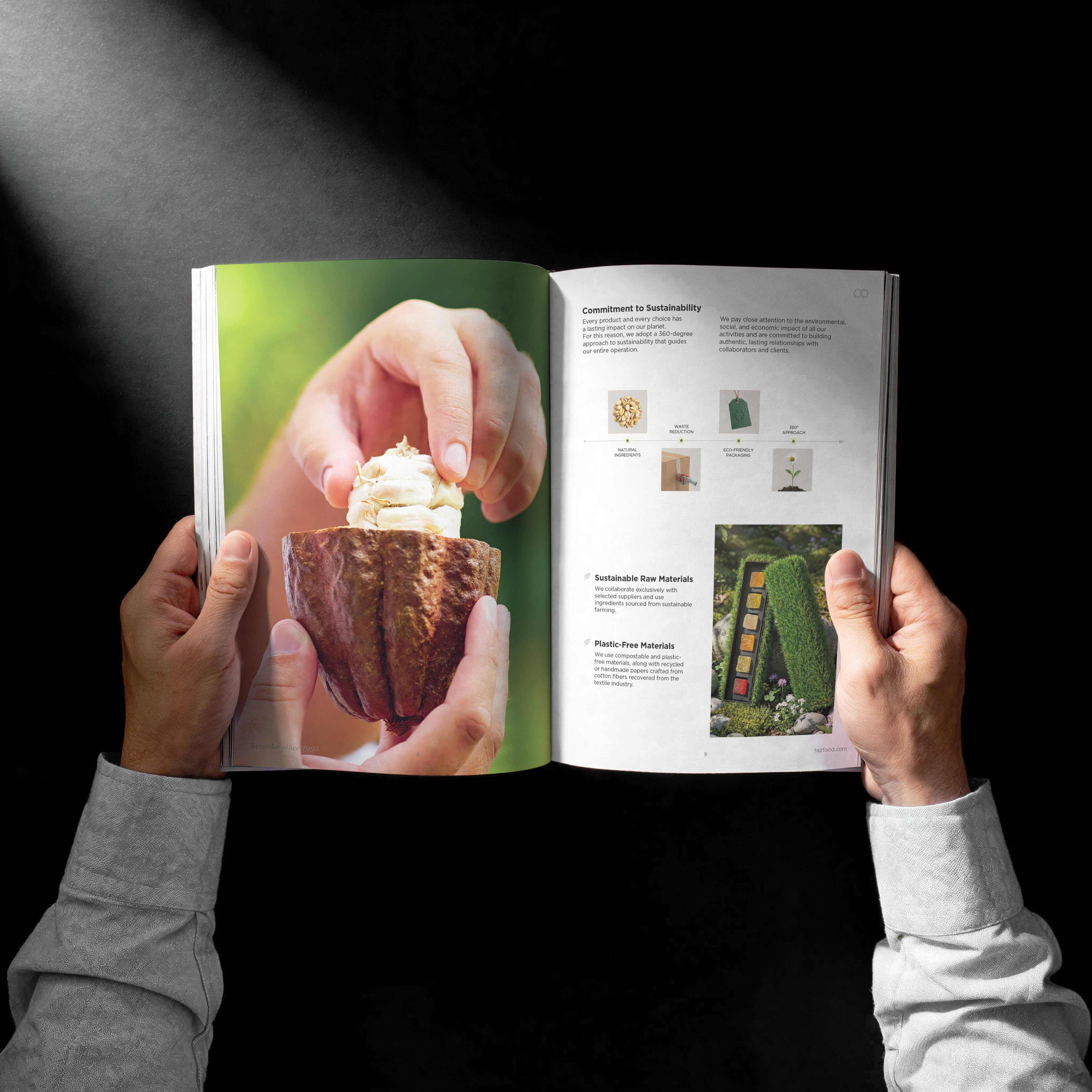 Hands holding an open magazine showing a large photo of a hand opening a cacao pod with cacao beans inside on the left page and text about sustainability with small images and a photo of a moss-covered display with colorful items on the right page.